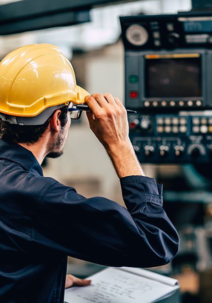 Specialized-Business-Insurance-Worker-in-Hard-Hat-Checks-Equipment-In-A-Manufacturing-Plant